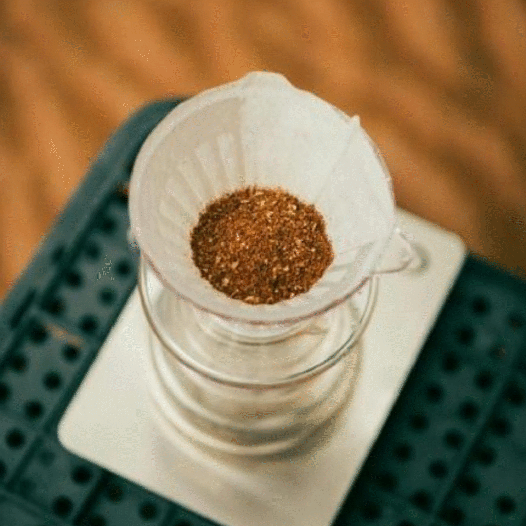 Versgemalen koffie in een papieren filter van een pour-over koffiemaker, klaar om te brouwen.